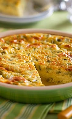 a quiche is shown in a green dish with one slice missing from the pie