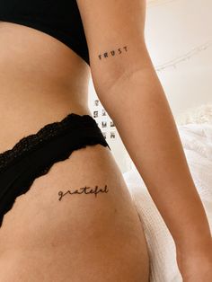 a woman's stomach with the word tattoo on her left side ribcage