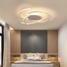 a bed sitting under a ceiling light in a bedroom