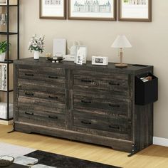 a large wooden dresser sitting in a living room next to a wall with pictures on it