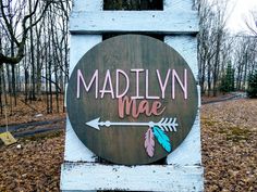 a wooden sign that says marilyn mae with an arrow on the front and arrows painted on the back