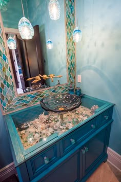 a bathroom vanity with a mirror and lights on it's sides, in front of a blue wall