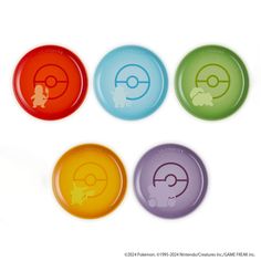 four different colored plates with pokemon symbols on them