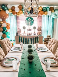 a dining room table set for a starbucks coffee themed birthday party with balloons and decorations