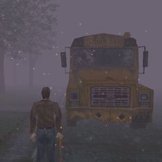 a man standing in front of a yellow school bus on a foggy day with trees