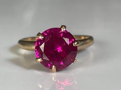 Beautiful ruby solitaire ring from the Victorian era in 10K yellow gold. This pretty ring features an antique 8.5mm ruby in an in a Tiffany-style 6-prong solitaire mount. The ruby is a beautiful shade of red with pink and fuschia undertones and is faceted for maximum fire. No visible chips, cracks or scuffs. Held firmly in place with six prongs in mint condition. Ring size 5 and easily sized up or down several sizes.  Please allow two weeks for sizing. One month layaway payment plans on items $500 and over available. Approximate Age - Victorian Gemstone(s) - tests as ruby on presidium gem tester (8.5mm) Metal - 10K yellow gold Weight - 2.6 grams Ring size - 5  Marks -  Makers Mark -  Comments -  Service & Sizing Information: If you require ring sizing or service, kindly follow the link bel Ruby Solitaire Ring, Rubin Ring, Pretty Ring, Antique Collectors, Tiffany Style, Pretty Rings, Ruby Ring, Shades Of Red, Victorian Era