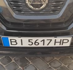 a close up of the front grille of a car with a blue and white license plate