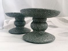 two stone pedestals sitting next to each other on a white cloth covered tablecloth