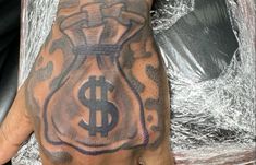 a man's hand with a tattoo on it and a money bag in the middle