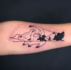 a person with a tattoo on their arm that has an image of a dog and cat