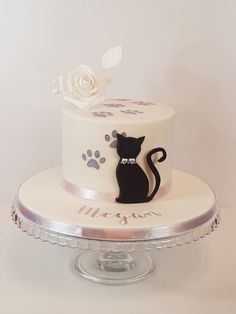 a white and black cake with a cat on top