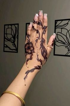 a woman's hand with hendix on it and flowers painted on the palm