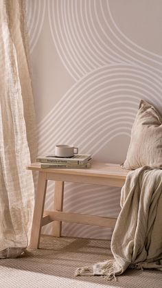 a wooden bench sitting in front of a window next to a book on top of a table