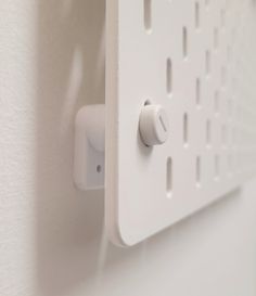 an electronic device mounted to the side of a wall next to a white door handle