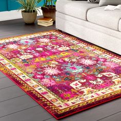 a living room area with a couch and rug on the floor, including a white sofa