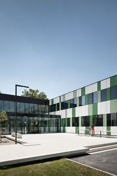 two people are standing in front of a building with green and white stripes on it