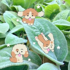 two stickers with dogs on them sitting on top of green leafy plant leaves