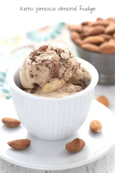 a bowl filled with ice cream and almonds on top of a white saucer