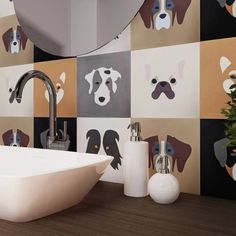 a white sink sitting next to a mirror on top of a wooden counter in front of a tiled wall