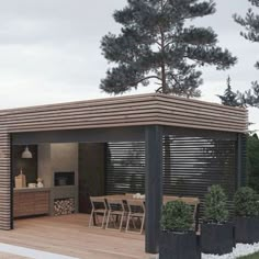 an outdoor kitchen and dining area is shown in this photo, surrounded by black planters