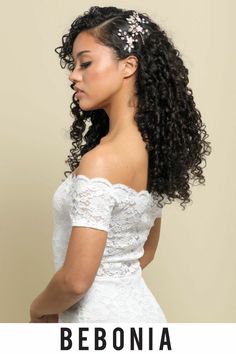 a woman with long curly hair wearing a white dress