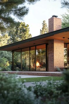 a brick house with glass walls and a fireplace