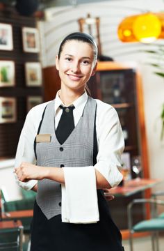 a woman in an office holding a piece of paper and smiling at the camera with her hands folded