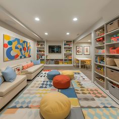 a brightly colored living room with lots of bookshelves and colorful rugs on the floor