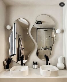 a bathroom with two sinks and mirrors on the wall