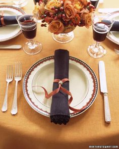 the table is set with plates, silverware and napkins