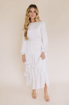 Step into something special with The White: Whitney. This exquisitely designed maxi-length white temple dress is made from a luxe silky material and features fully lined long sleeves, pockets! and a high rounded neck with a keyhole button closure. The double elastic waistband lends a romantic touch, and the tiered ruffle skirt seals the deal. Ready to step up your temple dress game? Look no further! Details Temple dress White dress Maxi-length Long sleeves Fully lined Pockets! High rounded neck White Temple Dress, Lds Temple Dress, White Temple, Temple Dress, Tiered Ruffle Skirt, Game Dresses, The Deal, Maxi Dress With Sleeves, Ruffle Skirt