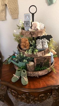 a wooden table topped with a tiered cake covered in stuffed animals