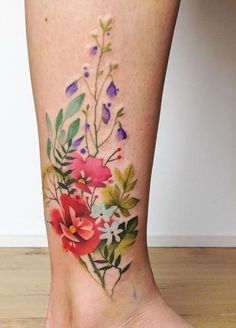 a woman's foot with flowers and leaves painted on the lower part of her leg