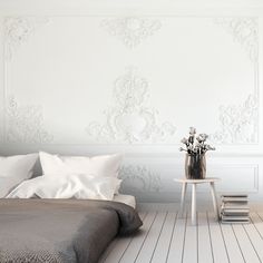 a bedroom with white walls and wood flooring is pictured in this image, the bed has two pillows on it