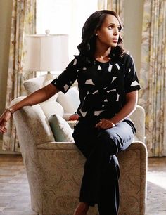 a woman sitting on top of a couch in a living room next to a window