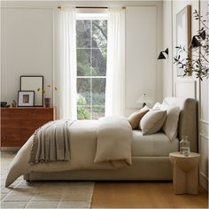 a bedroom with a bed, dresser and window in it's centerpieces