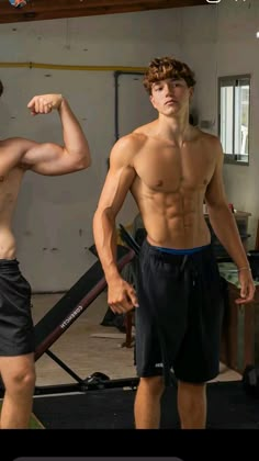 two young men flexing their muscles in the gym