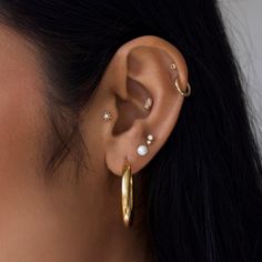 Introducing our stunning collection of 9k Solid Gold ear party pieces Dainty, Sparkly & Stackable styles designed to mix & match, creating a look that’s personal to you! These timeless treasures are made to last a lifetime, making them perfect for everyday wear in specialist ear piercings. Fits: Lobe, Upper Lobe & Conch Wear Pearl when manifesting luck and wealth. Read more in our guide to beautiful gemstones here  Buying a gift for someone special? Why not add the finishing touch with one of our gorgeous gift cards and gift bags? Click here to view Ear Stack With Conch, Ear Party Piercings, Cute Ear Stacks, Elegant Small Hoop Piercings, Tarnish Resistant, Stackable Earring Ideas, Single Gold-plated Cartilage Earring, Elegant Hypoallergenic Teardrop Piercings, Elegant Tarnish Resistant Piercings, Fine Jewelry Cartilage Drop Earrings