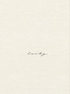 the words lucky are written in cursive ink on a white sheet of paper