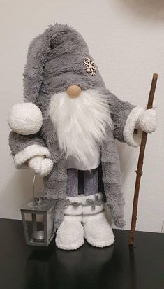 a stuffed gnome holding a stick on top of a table