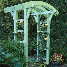 a green arbor with yellow roses growing on it