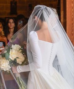 the bride is getting ready to walk down the aisle in her wedding dress and veil