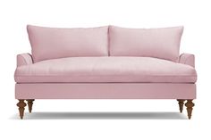 a pink couch with two pillows on the back and one arm upholstered to it