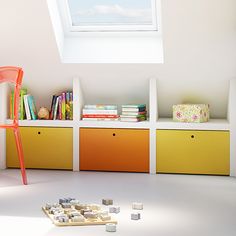 an orange chair sitting in front of a window next to bookshelves and toys