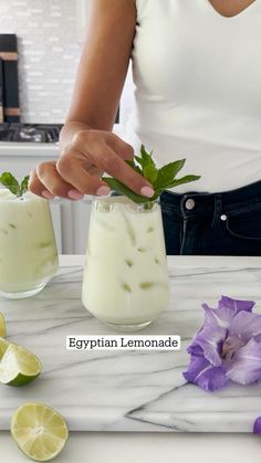 the woman is making a drink with lemons and mint