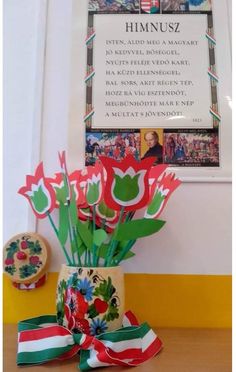 flowers in a vase sitting on a table next to a framed photo and an ornament