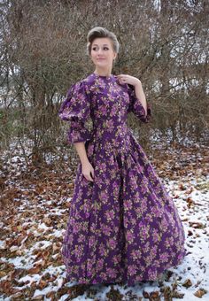 "You will find yourself looking for excuses to wear this lovely print dress! This Victorian styled dress has a high neckline at the front, and dips to a flattering \"V\" at the waistline. Buttons close the bodice at the front. The generously gathered skirt has pockets. The model is wearing a crinoline and boots and they are priced separately. 100% cotton. Hand or machine wash cold and tumble dry low. Recollections clothing is made in America.  The following are approximate finished measurements and include room for ease of movement.  BustWaist (in inches) XS36.528 S39        29.5 M41        31.5 L45        35.5 XL49        41 XXL51        44 3XL55.5        50 4XL59.556.5" Purple Floral Print Dress With Fitted Bodice, Purple Fitted Maxi Dress For Casual Occasions, Fitted Purple Maxi Dress For Casual Occasions, Fitted Maxi Length Prairie Dress, Fitted Floral Print Prairie Dress, Daywear Dress With Floral Print And Fitted Waist, Fitted Floral Print Maxi Length Prairie Dress, Fitted Floral Print Prairie Dress For Daywear, Fitted Prairie Dress For Daywear