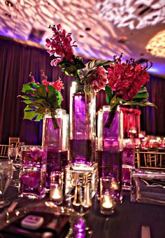 there are many vases with flowers in them on the table at this wedding reception