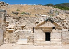 an old stone building in the middle of a rocky area with steps leading up to it