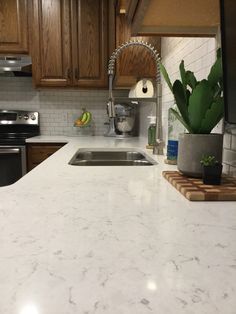 a kitchen with white marble counter tops and wooden cabinets